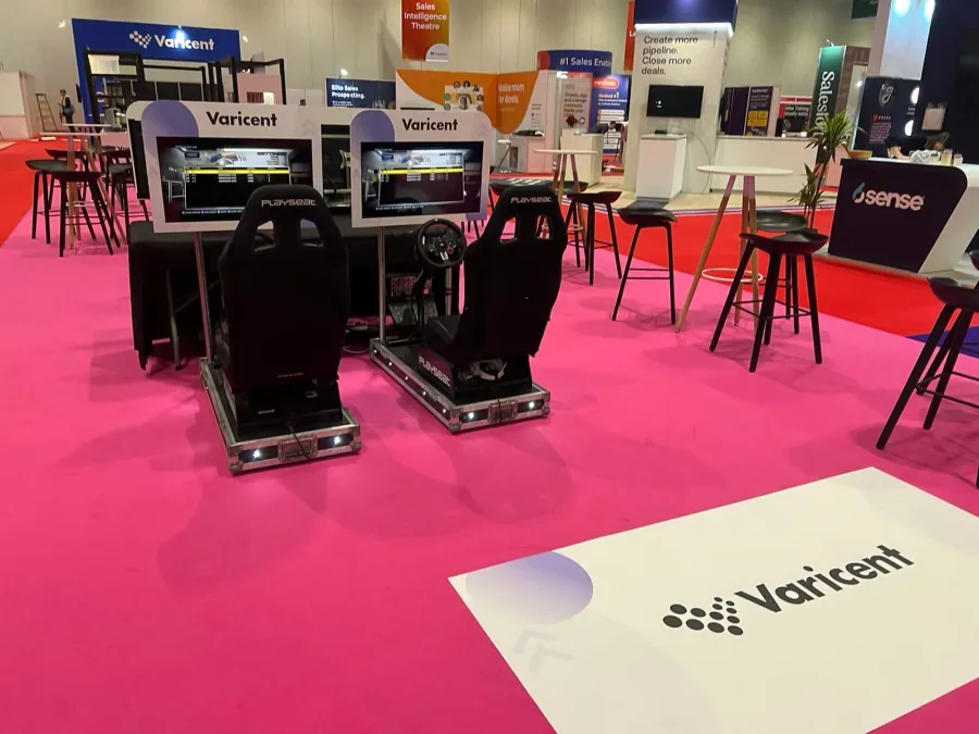 Twin racing simulators with branded screen surrounds at a trade show
